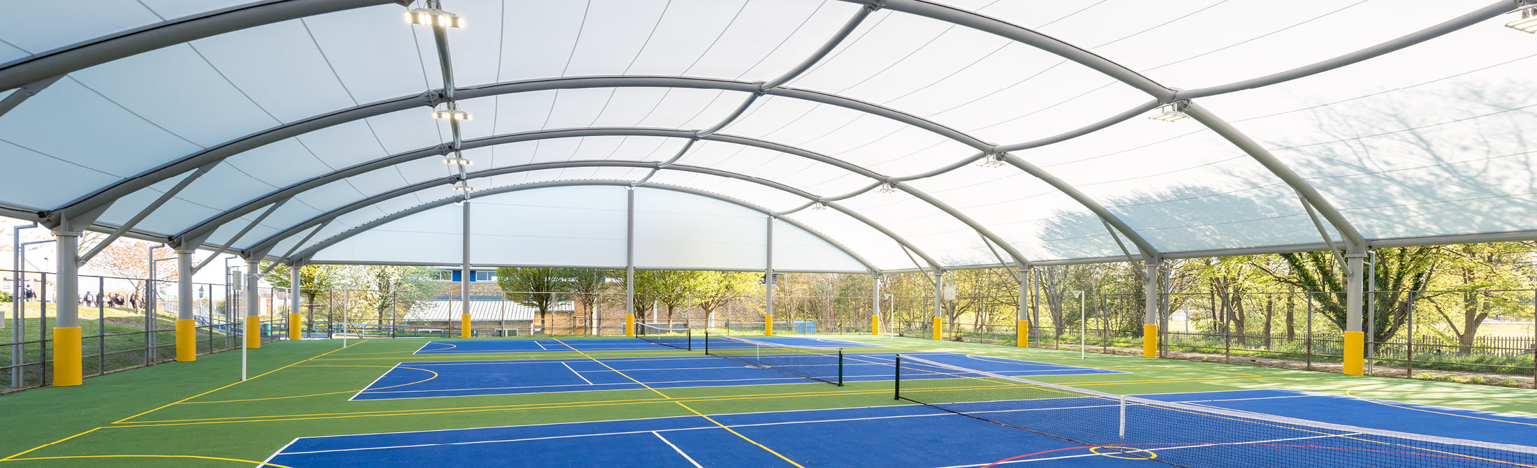 MUGA sports canopy covering multiple tennis courts