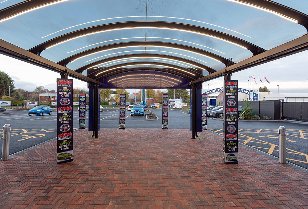 Glass entrance canopy outside of used car warehouse
